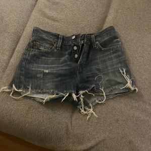 Slitna jeansshorts från Levi's - Säljer ett par snygga vintage Levi’s jeans , slitna jeansshorts från Levi's. 😄