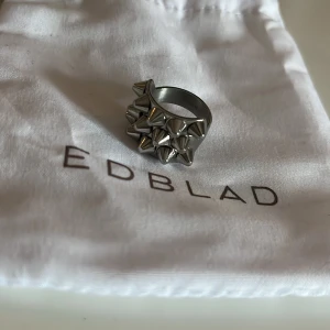 EDBLAD ring silver - Snygg och unik ring från Edblad i silverfärg med coola nitar som ger en edgy look. Perfekt för att ge din outfit en extra touch. Kommer med en praktisk förvaringspåse.