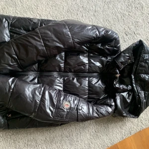 Svart pufferjacka från Moncler - Moncler Maya storlek M sitter mer som S! Den är rätt använt och lite sönder vi fickorna som kan fixas hemma eller hos en sömmerska! Märket är lite smutsigt men går att tvätta! Därav det låga priset!