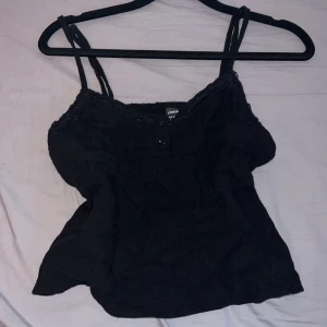 Svart linne från Shein - Säljer ett svart linne från Shein med spetsdetaljer och knappar framtill. Storlek S.