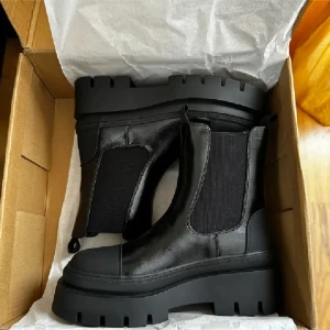 Svarta chelsea boots från Ellos - Snygga svarta chelsea boots med grov sula från Ellos. Tillverkade i skinn med elastiska paneler på sidorna för enkel på- och avtagning. Perfekta för en stilren look.