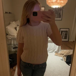 Ljusrosa stickad kortärmad tröja - Säljer en söt vit stickad tröja med korta ärmar och ett flätmönster. Storlek 170/ xs-s🩷 inte kommit till användning 