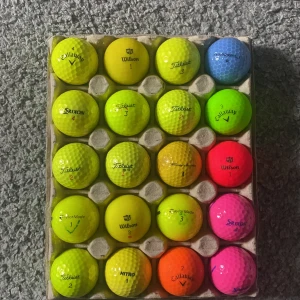 Färgglada golfbollar från olika märken - En samling av färgglada golfbollar från olika märken som Callaway, Wilson, Titleist, Srixon, TaylorMade och Nitro. Bollarna kommer i olika färger som gul, blå, orange, röd och rosa, perfekt för att lysa upp golfbanan. 20 stycken golfbollar.