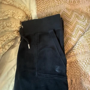 Mörkblå mjukisbyxor från Juicy Couture - Säljer mina mörkblå juicy couture byxor då de inte kommer till använding längre💘i storlek Xs men passar även mig som bär S.                          Har inte kommit till användning sedan 2023 när de var väldigt trendiga men även då användes de endast ett få tal gånger. Därav är de i super bra skick, iprincip nyskick🥰 nypris ca 1000 kr