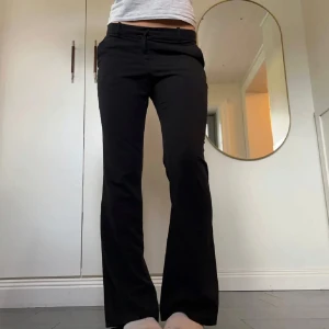 Svarta lågmidjade kostymbyxor - Svarta lågmidjade kostymbyxor från H&M i storlek 38. Tvärs över midjan är det ca 38 cm och innerbenslängden är ca 81 cm. Använd gärna köp nu!