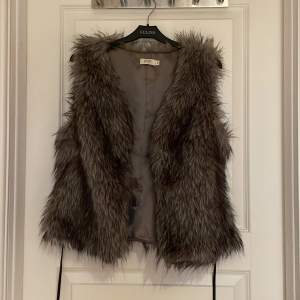 Säljer en snygg grå pälsväst från Jensen. Västen har en fluffig och mjuk textur med ett stilrent snitt. Perfekt för att lägga till lite extra stil till din outfit. 🐾 storlek 40 passar även som 38. Kan prutas.
