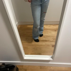 Ljusblå jeans med slitningar - Snygga ljusblå jeans med slitningar på knäna och låren. De har en klassisk femficksdesign och en bekväm passform. Perfekta för en avslappnad stil.