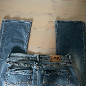 Blå jeans från Lee - Snygga blå jeans från Lee. De är bootcut och lågmidjade, mått syns på bilderna!💕