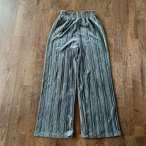 Blå byxor från Lindex - Snygga blå byxor från Lindex i ett mjukt och glansigt material. Byxorna har en elastisk midja och ett veckat tyg som ger en cool look. Perfekta för en stilren outfit. Står strl 158/164 men passar s/xs oxå. Hör gärna av er vid frågor och funderingar 💗💗