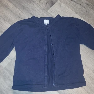 Mörkblå kofta från Club XPRS - Säljer en stilren mörkblå kofta från Club XPRS. Koftan har knappar framtill och är perfekt för lager-på-lager-stil. Den är långärmad och gjord i ett mjukt material som passar bra för kyligare dagar.