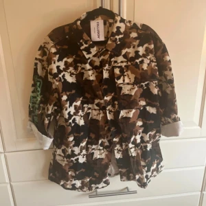 Camouflagejacka från Collusion - Säljer en camouflagejacka från Collusion. Jackan har ett unikt mönster i brunt, svart och vitt med gröna detaljer på ärmen💕
