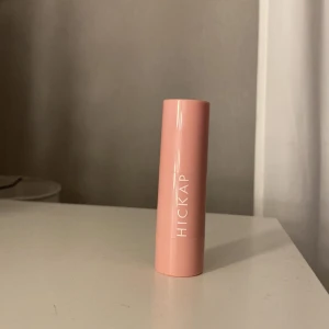 Blush från Hickap Färgen Shimmering coral - Säljer ett läppbalsam från Hickap i en söt rosa hylsa. Balsamet har en härlig orange nyans och är perfekt för att återfukta läpparna. Smidig att ha med i väskan för daglig användning.