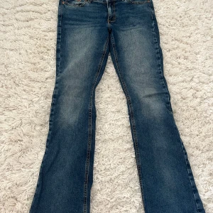 Blå bootcut jeans från Junkyard - Snygga blå bootcut jeans från Junkyard i klassisk denim. De har en knapp och dragkedja framtill samt fickor både fram och bak. Perfekta för en avslappnad stil. Nypris 600kr