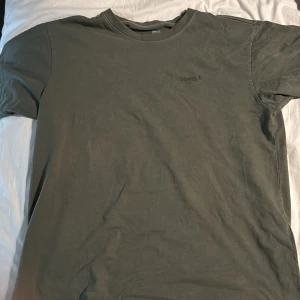 Grön t-shirt från Levi's - Säljer en grön t-shirt från Levi's med vintage fit. Den har en enkel design med korta ärmar och rund hals. Perfekt för en avslappnad stil.