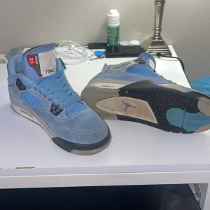 Nike Air Jordans i blå mocka - Säljer ett par Nike Air Jordans i blå mocka med svarta och grå detaljer. Skorna har snörning och en ikonisk Jumpman-logga på hälen. De kommer med originalkartong. Har tvättar dem med mocka borste så dem ser finare ut nu än på bilderna.