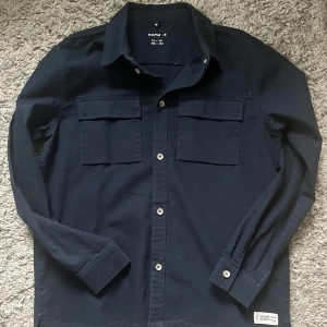 Mörkblå overshirt - Säljer nu en snygg och stilren mörkblå overshirt! Mycket bra skick endast använd fåtal gånger. Storlek 164 men kan även passa XS. ❗️Pris kan disktireas vid snabb affär❗️