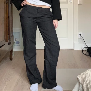 Grå rutig kostymbyxa - coola grå kostymbyxor med ett diskret rutmönster. byxorna har raka ben och låg midja . 