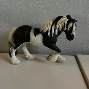 Schleich häst  - Detaljerad hästfigur i svart och vitt med realistisk man och svans. Perfekt för samlare eller som dekoration.