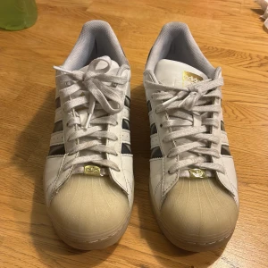 Adidas Superstar  - Adidas Superstar sneakers i vitt. bra skick har använts 1-3 gånger. är i storlek 42,5