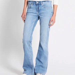 Blå bootcut jeans - Snygga ljusblå bootcut jeans med klassisk femficksdesign. De har en bekväm passform och är perfekta för en avslappnad stil. Jeansen är tillverkade i ett slitstarkt denimtyg och har en knapp- och dragkedjestängning. Låg midja.
