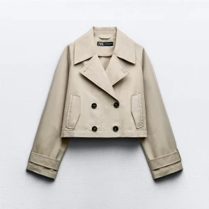 Beige croppad kavaj från Zara - Hej ! Helt ny använd 1 gång så ingen bild med jackan på! Snygg beige croppad kavaj från Zara med dubbelknäppning och breda slag. Jackan har långa ärmar med knappar vid ärmsluten och en dekorativ knappdetalj på ryggen. Perfekt för en stilren look.