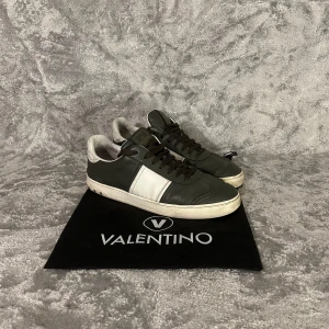 Valentino flycrew - Snygga Valentino sneakers i svart med vita detaljer. Skorna har en klassisk design med snörning och en bekväm sula. Perfekta för en stilren look.