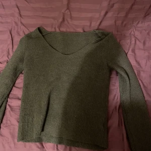Grön ribbad tröja från Shein - Säljer en grön ribbad tröja från Shein med v-ringning. Tröjan har långa ärmar och är perfekt för en avslappnad stil. Den är mjuk och bekväm att bära. Har knappt använt den☺️