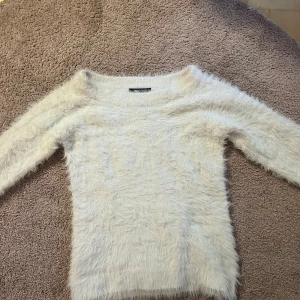 Vit fluffig tröja från Gina Tricot - Säljer en supermjuk och fluffig vit tröja från Gina Tricot!! Tröjan har långa ärmar och en normal passform. Endast provad på, går inte att köpa hos den längre 