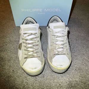Vita sneakers från Philippe Model - Snygga vita sneakers från Philippe Model med grå detaljer och snörning. Skorna är köpta på miinto och de passar 44/45