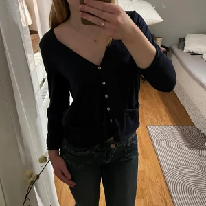 Svart kofta med knappar - Säljer en stilren svart kofta med knappar och fickor framtill. Koftan har långa ärmar och en v-ringad design, perfekt för en avslappnad look. (Jeansen finns i en annan annons) 🎀