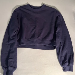 Mörkblå croppad sweatshirt från H&M - Säljer en stilren mörkblå croppad sweatshirt från H&M (divided)  med långa ärmar och bredare passform. Perfekt för en avslappnad look. Använd men inte sliten. Säljer då den tyvärr inte kommer till användning längre. Passar bra till en casual och avslappnad look. Kontakta mig för mer information.💙