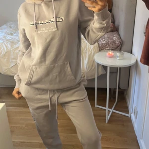 Ljuslila set från Closure - Säljer en lilaaktigt set från Closure med tryck framtill och på vänster ben. Den har en bekväm passform med långa ärmar och en praktisk ficka vid magen. Vanlig i midjan/kan göra den lågmidjad. Perfekt för en avslappnad stil. Huvan har dragsko för justering. Ganska stretchig och overdosed. Passar XS-M