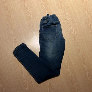 Mörkblå jeans med resårmidja - Säljer ett par mörkblå jeans från LAB Industries. De har en bekväm resårmidja och en klassisk femficksdesign. Perfekta för en avslappnad stil med en snygg tvättad look.