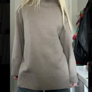 Beige stickad polotröja - Mysig mörkbeige stickad polotröja, strl L. Slits på sidan