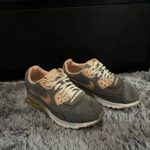 Nike Air Max i grått och beige - Säljer ett par snygga Nike Air Max sneakers i grått och beige. De har en klassisk design med snörning och en bekväm sula. Perfekta för både vardag och träning. Skorna är i bra skick och redo för nya äventyr!