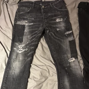 Svarta jeans från Dsquared2 - Säljer ett par svarta Dsquared2 jeans i bra skick då jag växt ur dom. De har en cool distressed look med slitningar och Dsquared lapp på framsidan. Hör av er om pris förslag. Kan nog sänka priset lite vid snabb och enkel affär😁 