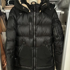 Svart jacka från Rockandblue - Säljer en svart dunjacka från Rockandblue i storlek 34. Jackan har en mysig fodrad insida och är perfekt för kalla vinterdagar. Den har en dragkedja framtill och flera praktiska fickor. Huvan är justerbar och jackan har en stilren design. Perfekt för både vardag och vinteräventyr! ❄️