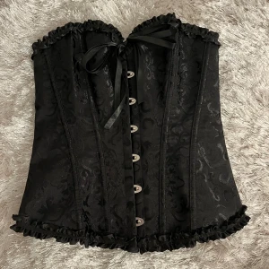 Svart korsett - Snyggaste korsetten nu till halloween, slutsåld typ överallt. Storlek S men justerbar. Sitter as snyggt på! Använd 1 gång med skickas ändå i originalförpackninhen. POSTAR SAMMA DAG SÅ DET HINNER KOMMA FRAM!! Kolla min profil för mer halloween saker💞💞