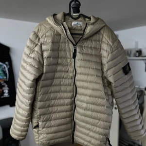 Stone island jacka - Dunjacka av märket Stone island, Den är endast använd denna våren. I storlek L men sitter som M! Fler bilder kan fås i Dm.