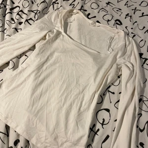 Vit långärmad topp från H&M - Säljer 2  vita långärmade toppar från H&M.  Ena är storlek S andra är st M 