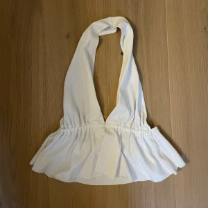Fin halterneck topp med volang och öppen rygg - Använd fåtal gånger, normal i storleken! Väldigt fint skick!!