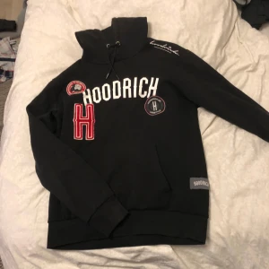Svart hoodie från Hoodrich - Säljer en svart hoodie från Hoodrich i mycket bra skick. Den har coola broderade detaljer och en stor ficka fram. Perfekt för höst och vinter, och den är superbekväm med en normal passform. Perfekt för att hålla stilen när det blir kallt ute!