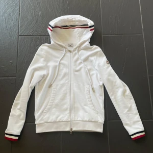 Moncler hoodie - Hej, Säljer nu min hoodie i storlek s eftersom att jag har växt ur den. Hoodien är i bra skick, ej sliten och inga hål eller liknande. Mitt pris är 1300kr men kan förhandlas. Tveka ej på att att kontakta om ni har några funderingar!