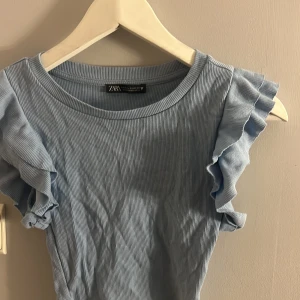 kortärmade tröjor - säljer dessa superfina tröjorna med volang vid armen. Köpt ifrån zara och båda är i strl S. En är blå och en svart.  40kr st
