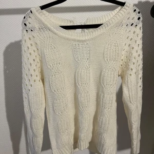 Vit stickad tröja med knytband - Superfin vit stickad tröja med ett snyggt hålmönster och knytband i ryggen. Perfekt för både höst och vinter. Den har långa ärmar och en bekväm passform. Perfekt för att hålla sig varm och stilren! Den är knappt använd💗😆