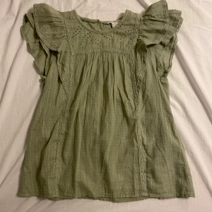 Grön blus med volangärmar - En grön blus med volangärmar och broderat mönster upptill. Använt två gånger och säljer för att den är lite för stor för mig. Från märket Esprit i storlek M💞