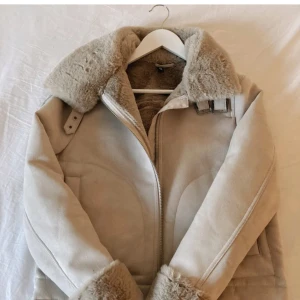 Beige pälsjacka med dragkedja - Säljer en supermysig beige pälsjacka med fluffig krage och muddar. Den är både snygg och varm, perfekt för vintern! Köpte för 699 och säljer lite billigare men pris kan diskuteras💞