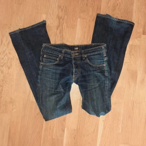 Mörkblå jeans från Lee - Jag säljer dessa så snygga lågmidjade och utsvängda jeansen av märket Lee! Säljer för att dom tyvärr inte passade mig 💔 Midjemåttet är 40 cm och innerbensländen är 83 cm. Dom var inte bootcut från början. Kontakta mig vid frågor 💕💕