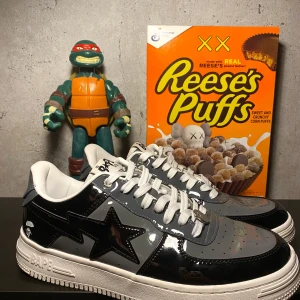 Svarta och grå sneakers från BAPE - Säljer ett par snygga BAPE STA sneakers i svart och grått. Skorna har en glansig finish. De är i bra skick och är väldigt sköna. Dom är använda så fråga om ni vill ha mer bilder 👍 Storlek 44