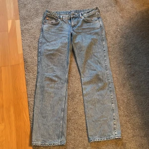 Blå jeans från Weekday - Säljer ett par snygga blå jeans från Weekday. De är i modellen 'Arrow Low Straight Jeans' och har en klassisk femficksdesign. Jeansen är i storlek W29 L32 och har en låg midja med rak passform. Perfekta för en avslappnad vardagslook!